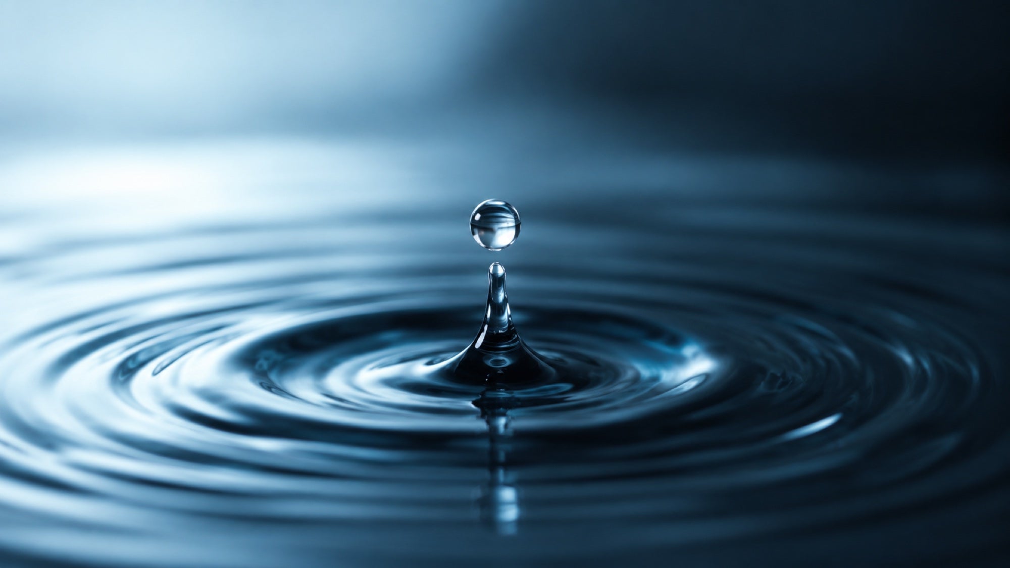 Une goutte d'eau créant des ondes concentriques sur une surface calme